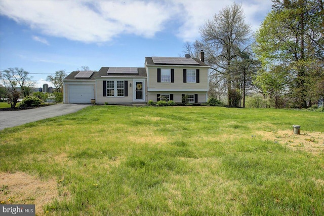 2284 Pine Rd, Newville, PA 17241 - tri-level home with a front lawn, driveway, a chimney, an attached garage, and roof mounted solar panels