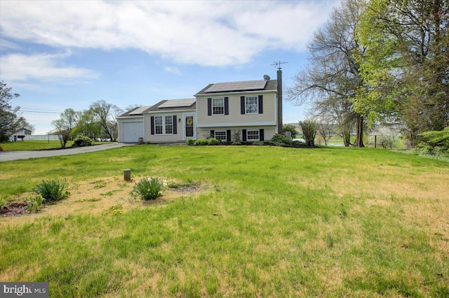 2284 Pine Rd, Newville, PA 17241 - split level home with solar panels, a chimney, a garage, a front yard, and aphalt driveway