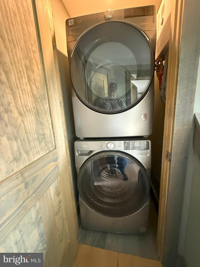 washroom featuring stacked washer and dryer and laundry area