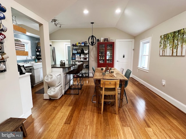 dining space featuring recessed lighting, vaulted ceiling, wood finished floors, and baseboards