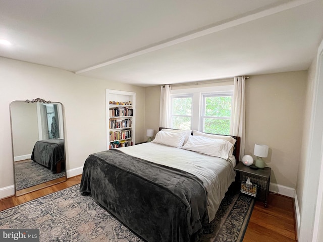 bedroom with wood finished floors and baseboards