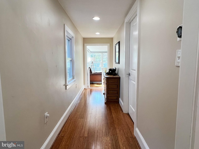 hall featuring dark wood finished floors, baseboards, and recessed lighting