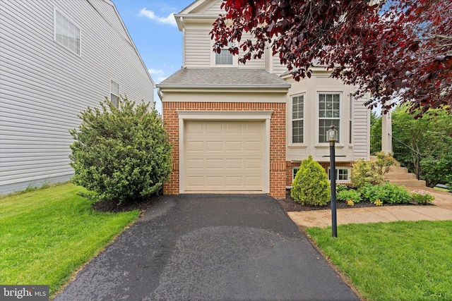 6780 Hollow Glen Ct, Gainesville, VA 20155 - view of front of house featuring brick siding, a garage, asphalt driveway, a front lawn, and roof with shingles