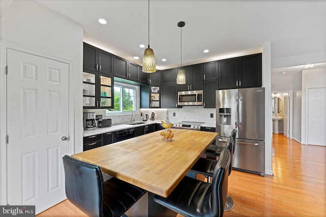 6780 Hollow Glen Ct, Gainesville, VA 20155 - kitchen featuring stainless steel appliances, light wood-style floors, a sink, tasteful backsplash, and recessed lighting