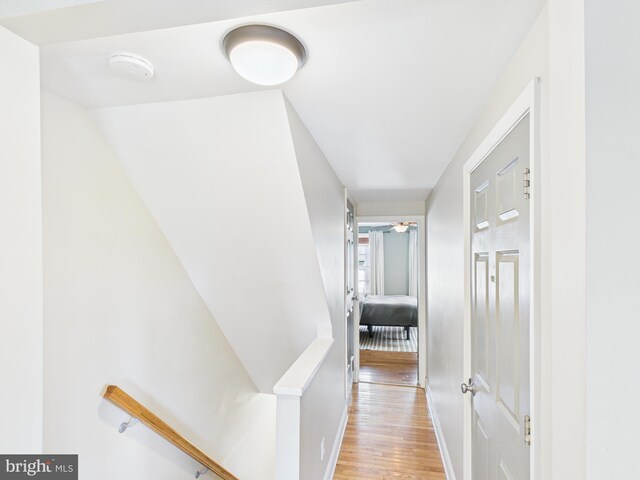 hall with light wood finished floors and baseboards