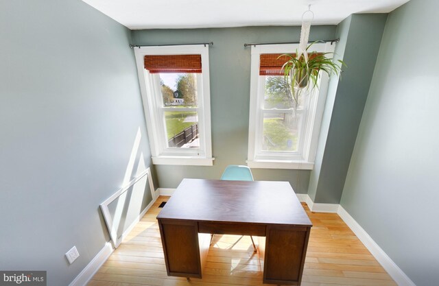 dining space featuring light wood finished floors and baseboards