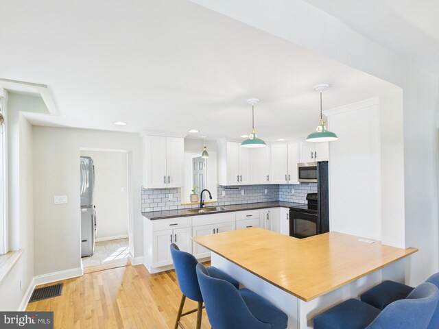 kitchen featuring white cabinets, a breakfast bar area, appliances with stainless steel finishes, and tasteful backsplash