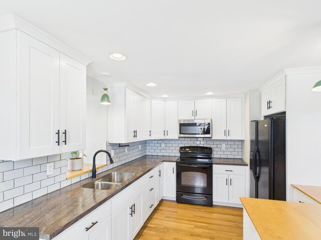 kitchen featuring black appliances, backsplash, a sink, and white cabinets