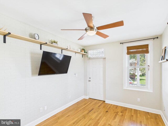 empty room with light wood-style floors, baseboards, and ceiling fan