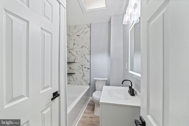 bathroom featuring wood finished floors, vanity, washtub / shower combination, and toilet
