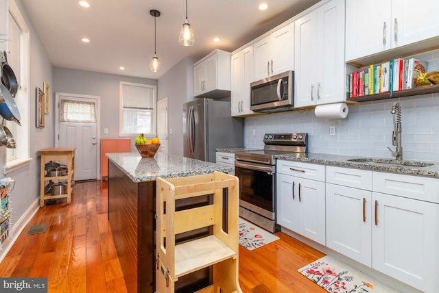 kitchen with tasteful backsplash, open shelves, a sink, stainless steel appliances, and visible vents