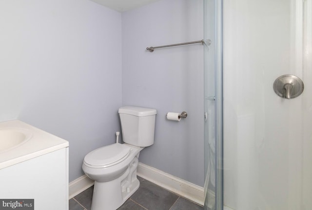 bathroom featuring tile patterned floors, vanity, a shower, baseboards, and toilet
