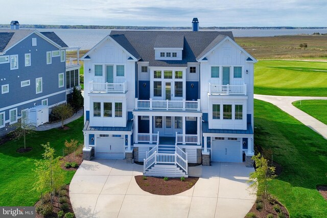 view of front of property with a garage, a balcony, concrete driveway, board and batten siding, and a front yard