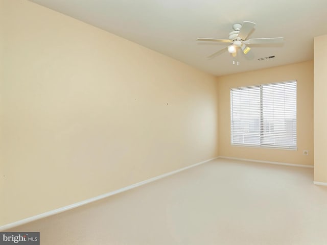 empty room with baseboards, ceiling fan, and light colored carpet