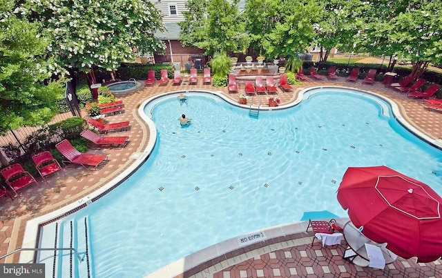 community pool featuring fence and a patio