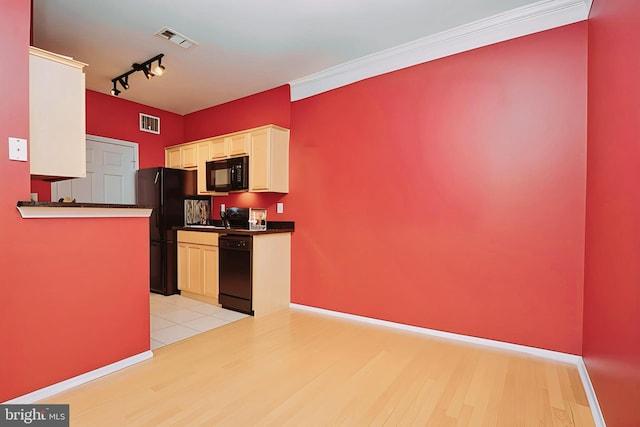 kitchen featuring dark countertops, black appliances, light wood finished floors, and visible vents