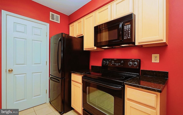 kitchen with visible vents, light tile patterned floors, black appliances, and dark stone countertops