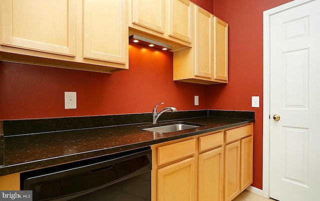 kitchen with black dishwasher, light tile patterned floors, light brown cabinetry, and a sink