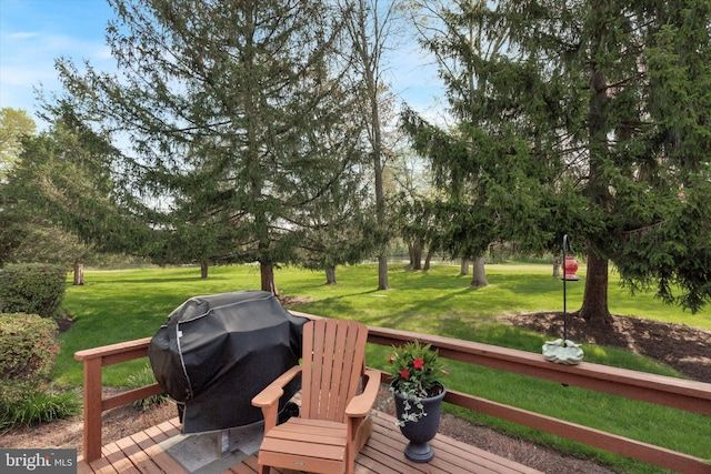 wooden deck featuring a lawn and area for grilling