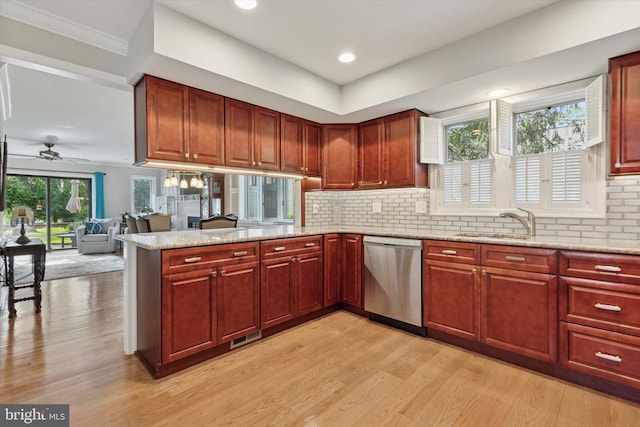 kitchen featuring light wood finished floors, a sink, ceiling fan, a peninsula, and dishwasher