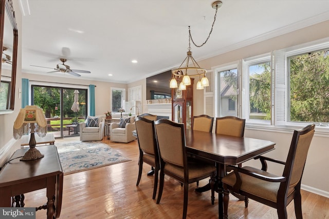dining area featuring a healthy amount of sunlight, light wood-type flooring, ornamental molding, and baseboards
