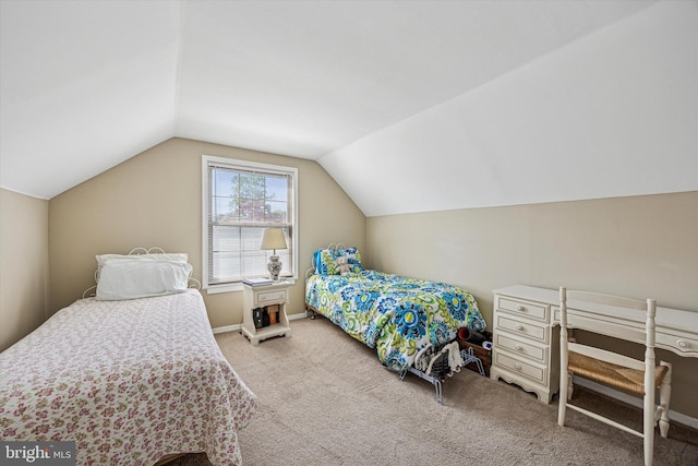 carpeted bedroom with baseboards and vaulted ceiling