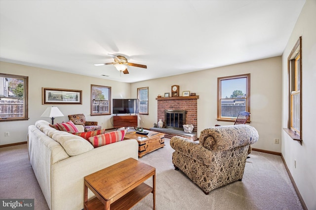 living area with light colored carpet, a fireplace, a ceiling fan, baseboards, and visible vents
