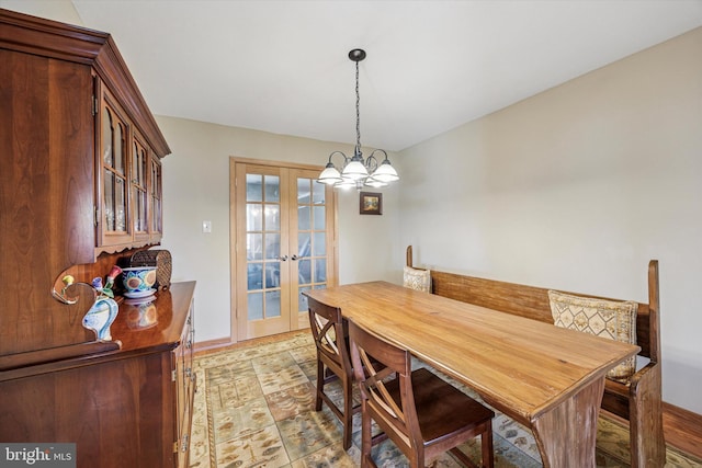 dining room with baseboards, french doors, and a notable chandelier