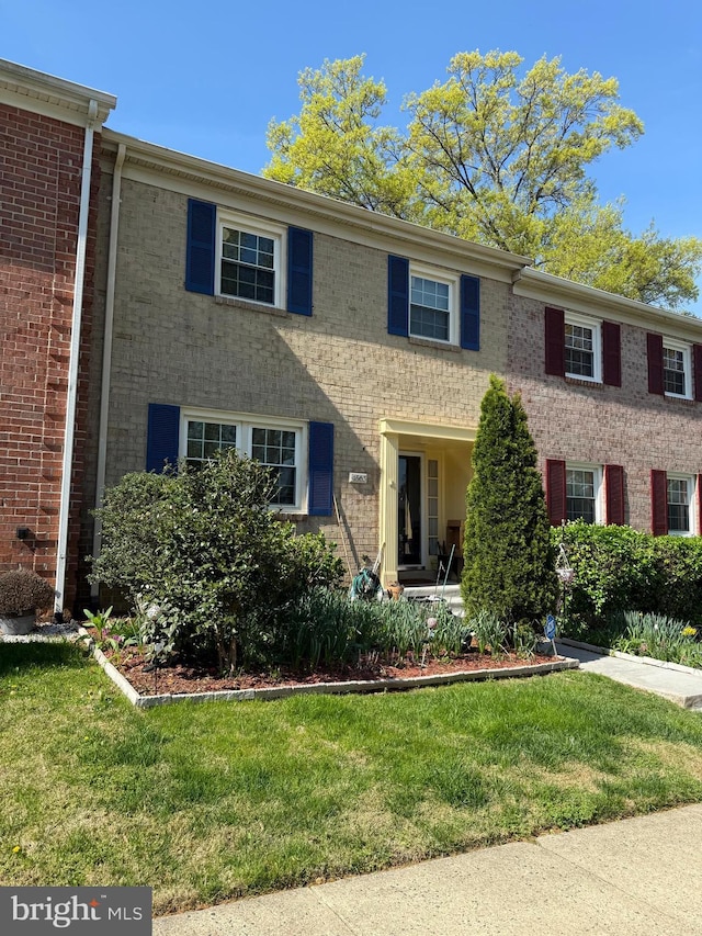 view of front of home featuring brick siding and a front yard