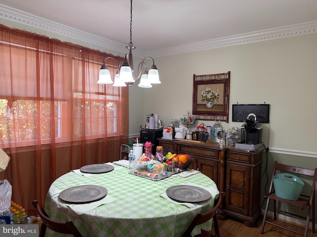 dining space featuring a notable chandelier, wood finished floors, and crown molding