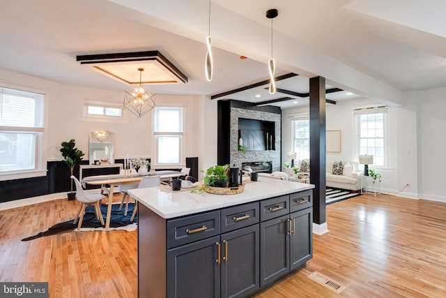 kitchen with an inviting chandelier, light countertops, open floor plan, light wood-type flooring, and visible vents