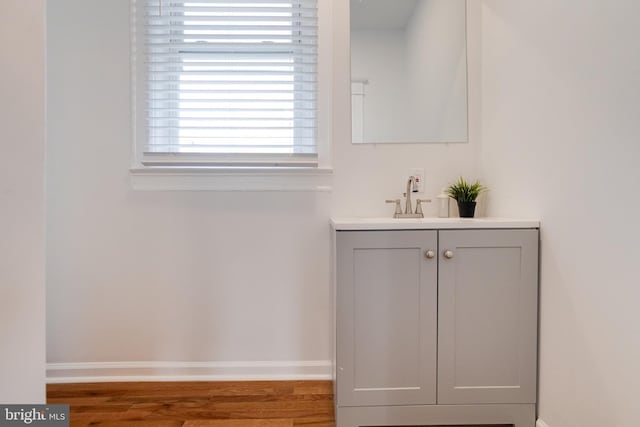 room details featuring baseboards, wood finished floors, and vanity