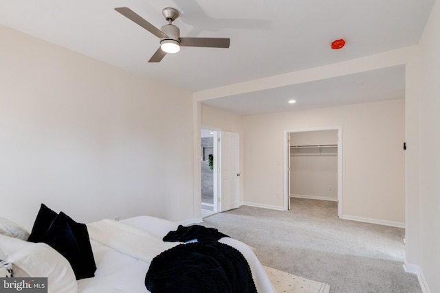 bedroom featuring baseboards, ceiling fan, carpet flooring, and a spacious closet