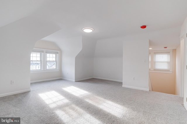additional living space with baseboards, carpet, and lofted ceiling
