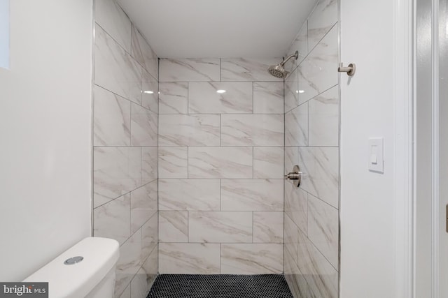 bathroom featuring toilet and a tile shower