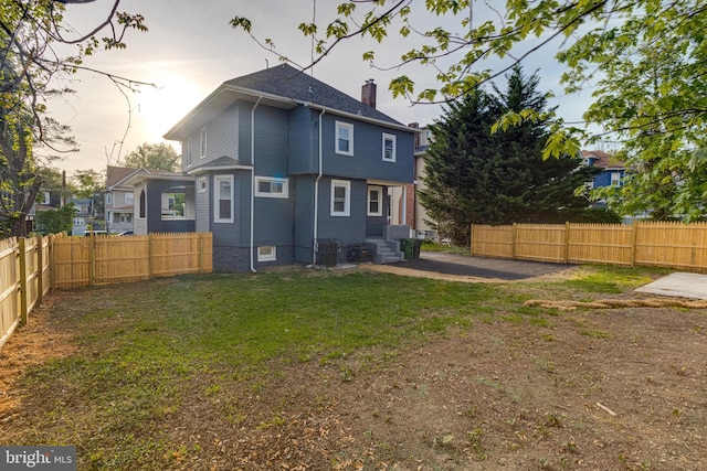 rear view of house with cooling unit, a patio, a fenced backyard, a chimney, and entry steps