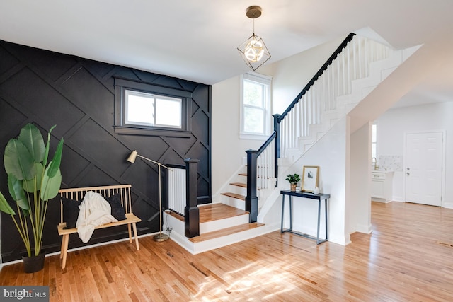 entryway featuring baseboards, stairs, and light wood-style flooring