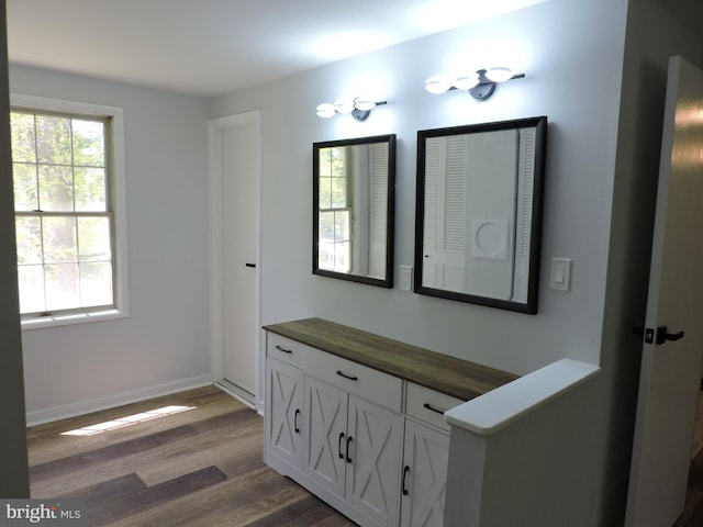 bathroom featuring wood finished floors, vanity, and baseboards