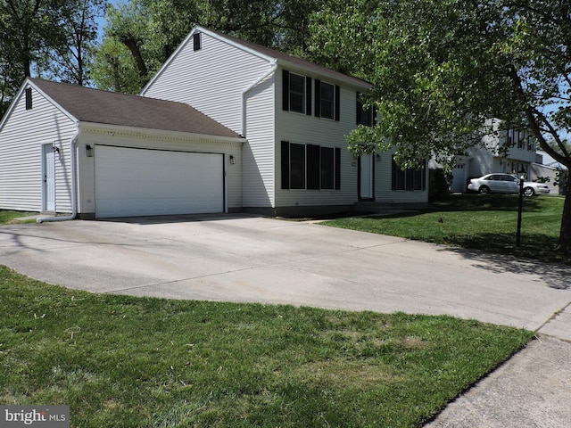 colonial inspired home with a garage, concrete driveway, and a front lawn