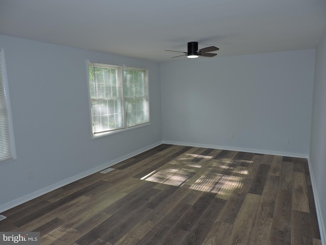 empty room with ceiling fan, dark wood-style flooring, and baseboards