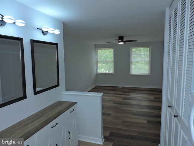hall with dark wood-style floors and baseboards