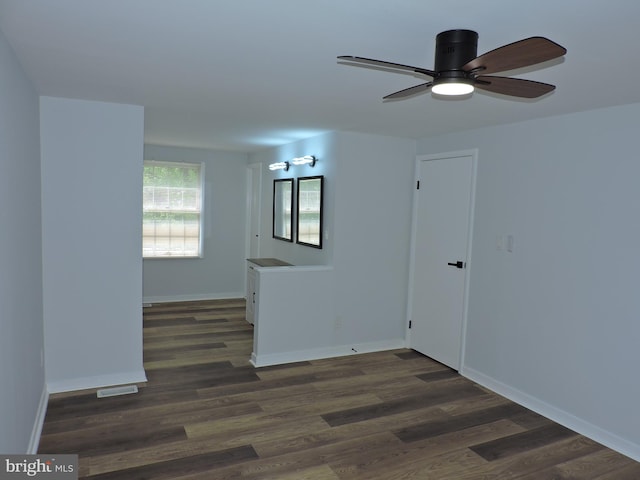 spare room featuring wood finished floors, ceiling fan, and baseboards