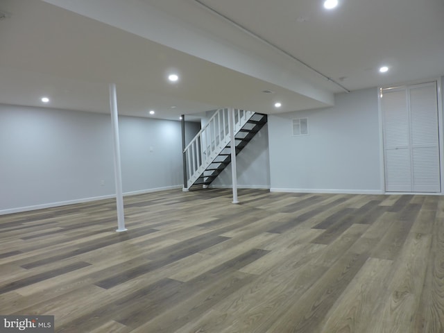 finished basement featuring baseboards, wood finished floors, stairway, and recessed lighting