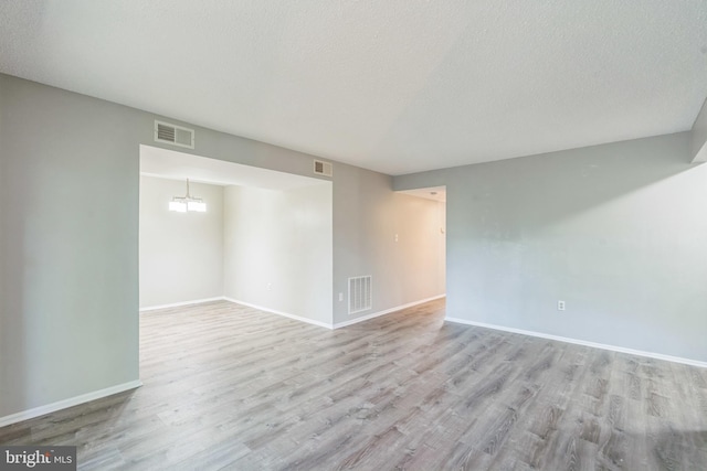 7743 Inversham Dr Unit 197, Falls Church, VA 22042 - empty room featuring wood finished floors, a textured ceiling, and a chandelier