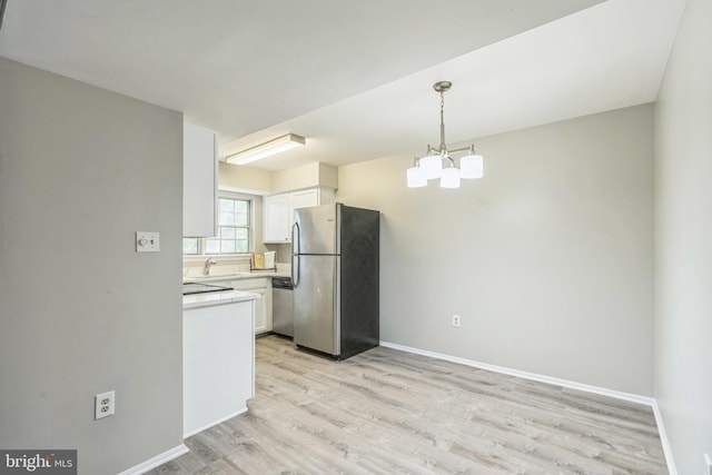 7743 Inversham Dr Unit 197, Falls Church, VA 22042 - kitchen featuring appliances with stainless steel finishes, white cabinetry, light wood-style floors, light countertops, and hanging light fixtures