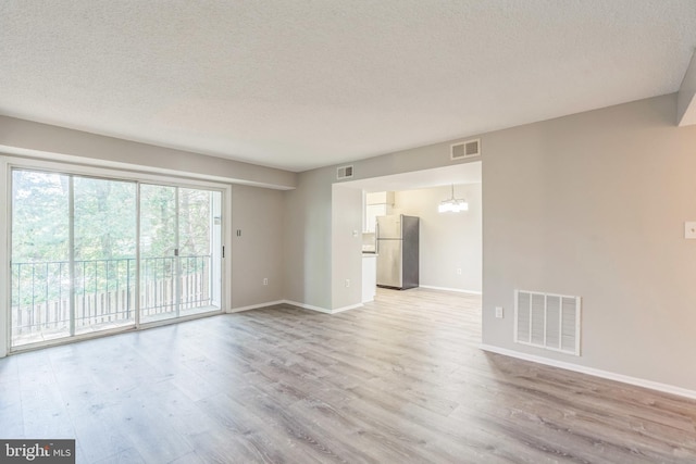 7743 Inversham Dr Unit 197, Falls Church, VA 22042 - unfurnished living room with light wood finished floors, a chandelier, and a textured ceiling