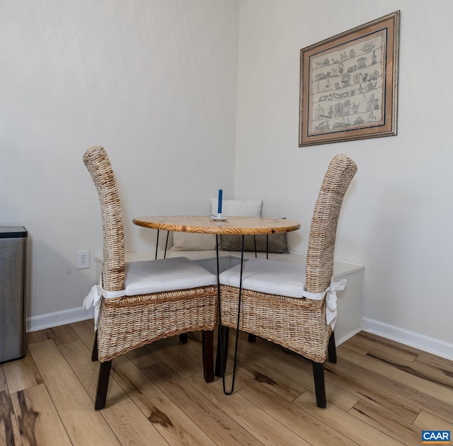 dining space featuring light wood-style flooring and baseboards