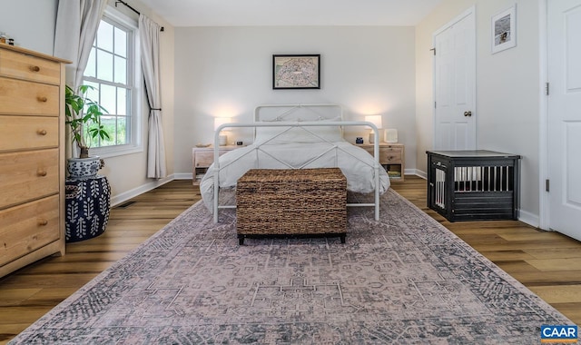 bedroom featuring wood finished floors, visible vents, and baseboards