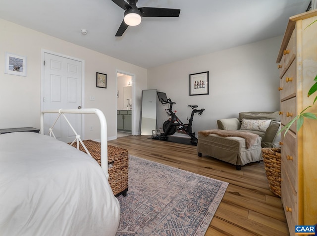 bedroom featuring a ceiling fan, wood finished floors, and ensuite bathroom