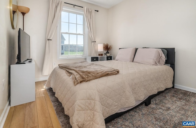 bedroom featuring baseboards and wood finished floors